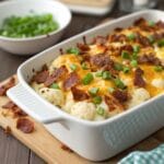 Loaded cauliflower casserole topped with cheese and turkey bacon