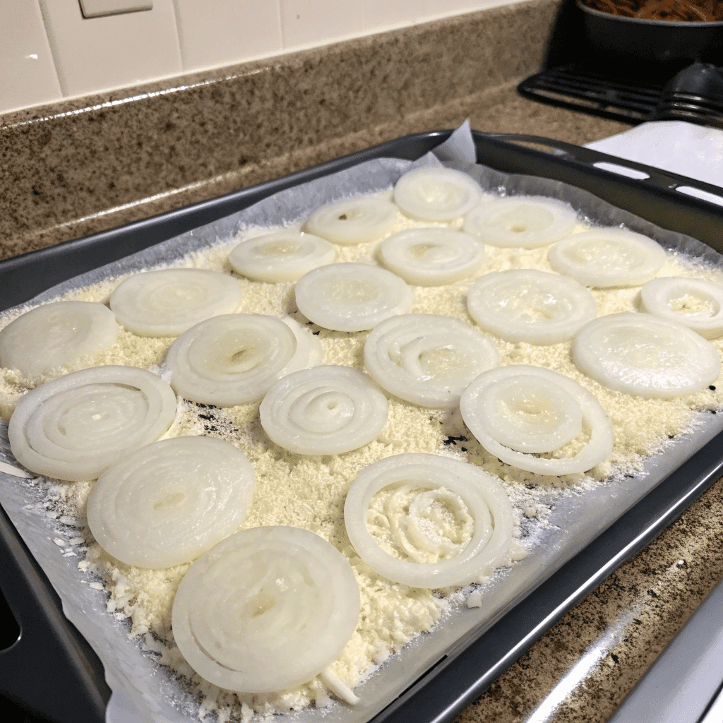 Onion rings laid on cheese layer before baking